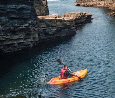 man riding kayak on body of water man riding kayak on body of water