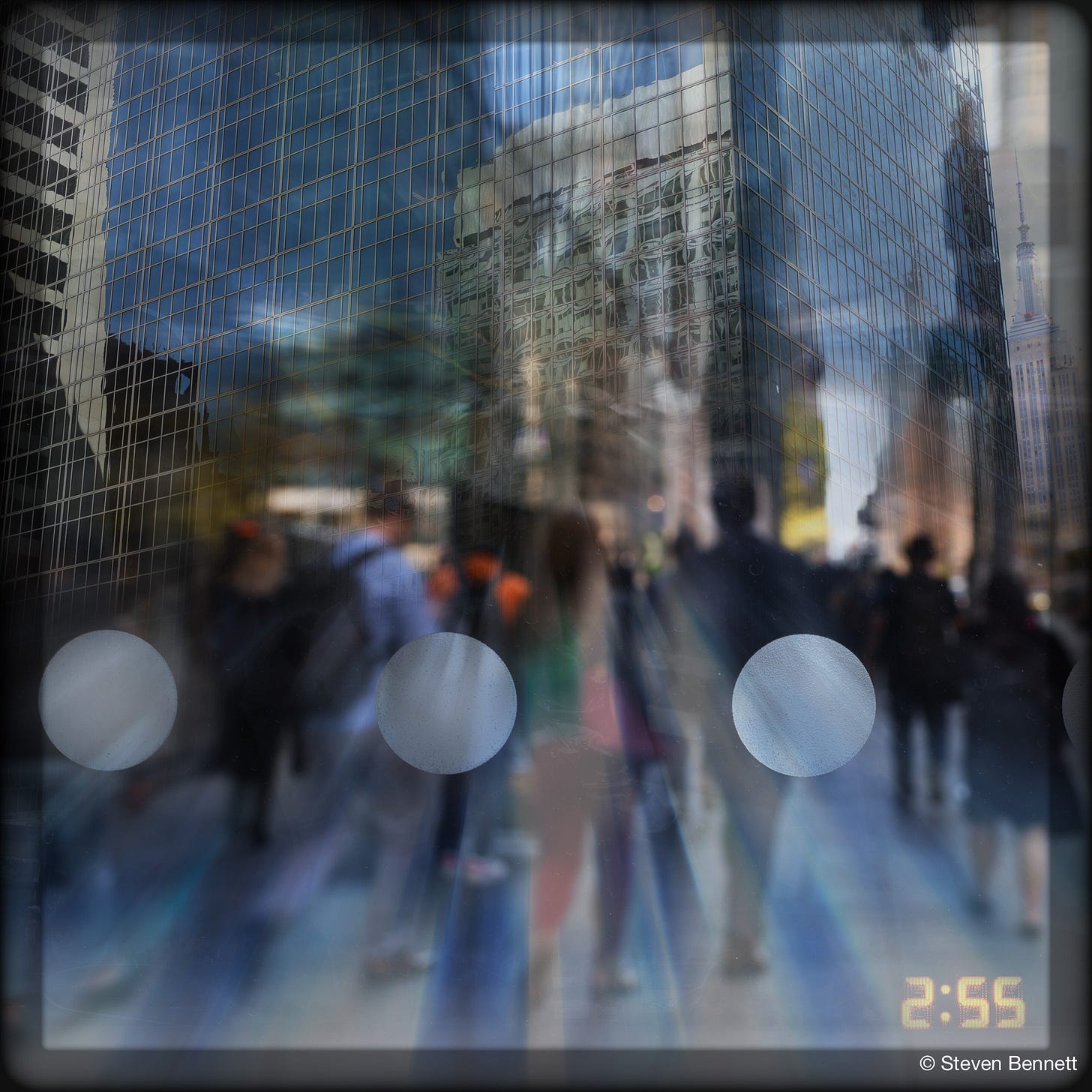 Composite photograph looking out from inside a bus shelter onto a midtown Manhattan sidewalk. Blurred pedestrians stride between glass towers, the Empire State Building visible at upper right. Three frosted circles printed on the shelter glass float across the scene, and a digital timestamp in the corner reads 2:55. Composite photograph looking out from inside a bus shelter onto a midtown Manhattan sidewalk. Blurred pedestrians stride between glass towers, the Empire State Building visible at upper right. Three frosted circles printed on the shelter glass float across the scene, and a digital timestamp in the corner reads 2:55.