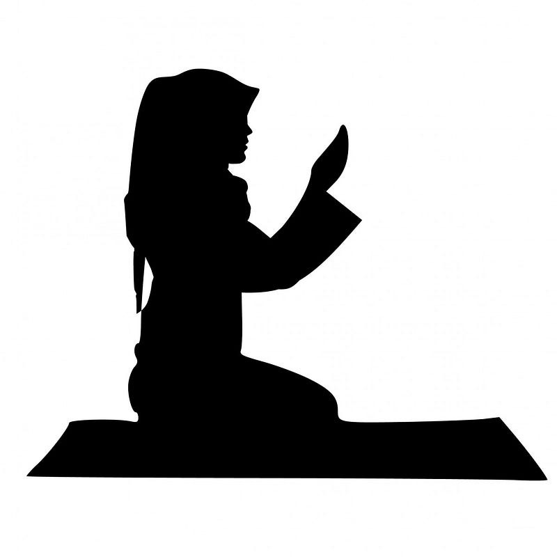 A muslim woman praying on a mat A muslim woman praying on a mat