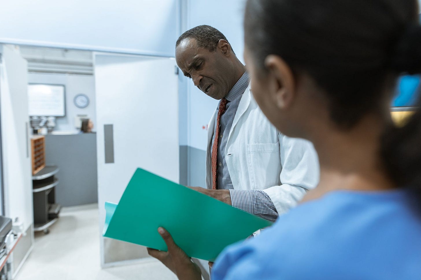 Photo by RDNE Stock project on Pexels Doctors examining a folder in a hospital setting, highlighting teamwork and healthcare professionalism. (stock photo)