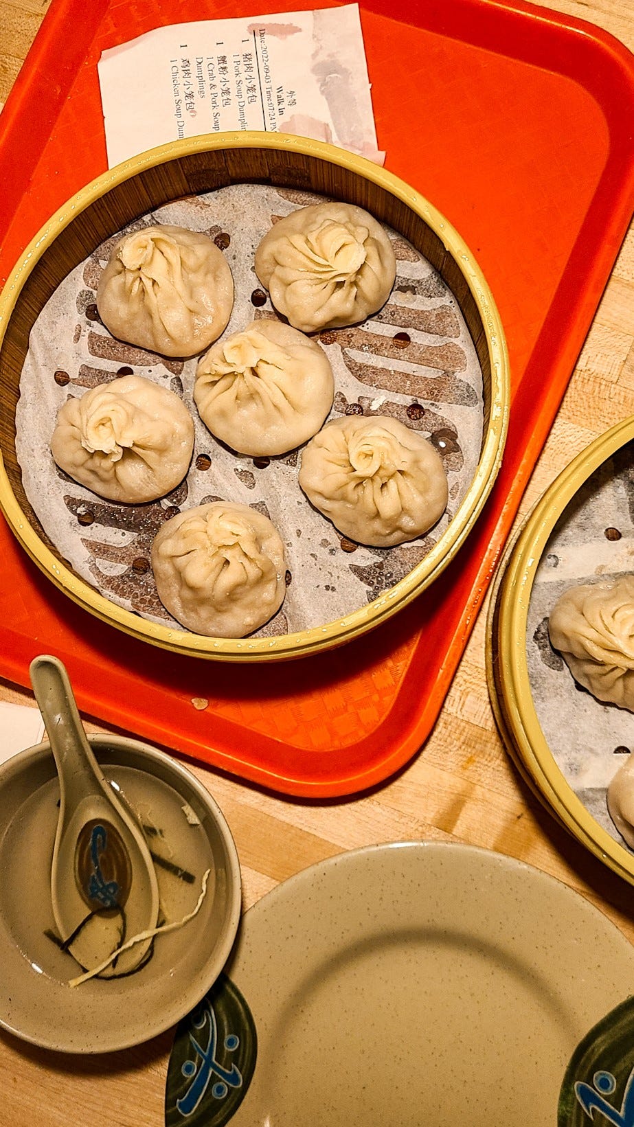 Pleated Shanghai soup dumplings filled with pork served on bamboo steamer