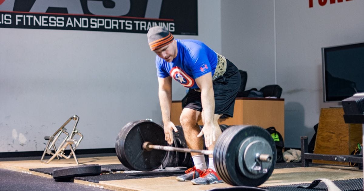 Man performing a barbell deadlift Man performing a barbell deadlift