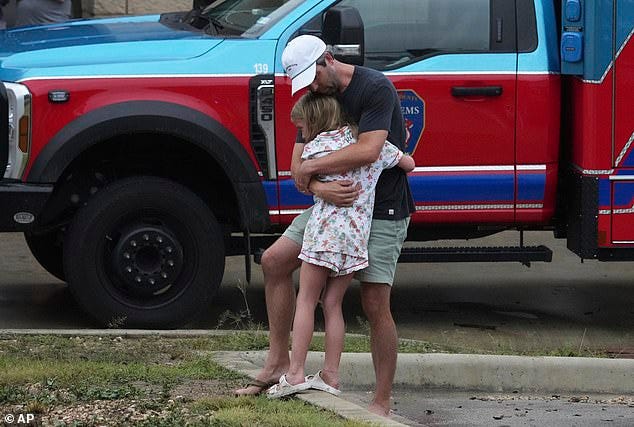 Pictured: A dad hugging his daughter tight at a reunification center in Ingram. Twenty-four people died during the massive floods in Texas, most of which were children attending a summer camp. More than 20, many children, are still missing