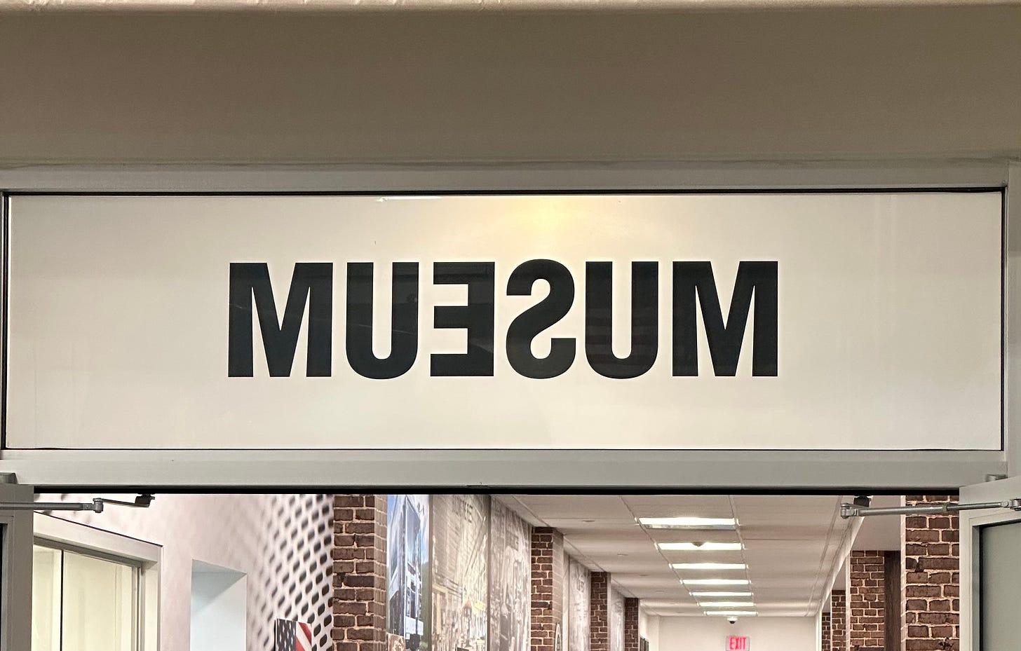 Back side of "Museum" sign showing reverse image of letters.