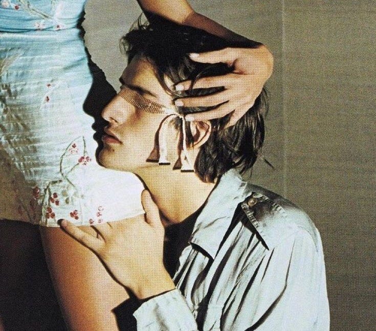 This may contain: a young man is holding his head in front of the woman's face