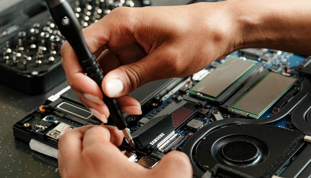 A person is working on a piece of electronics