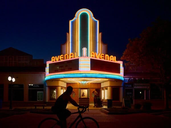 A theater with neon signage reading, “Avenal.”