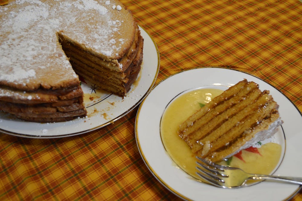 Plate of apple stack cake with syrup on a checkered tablecloth