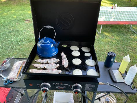 A blackstone griddle, cooking various meals, and a fire ring with marshmallows and a chocolate center