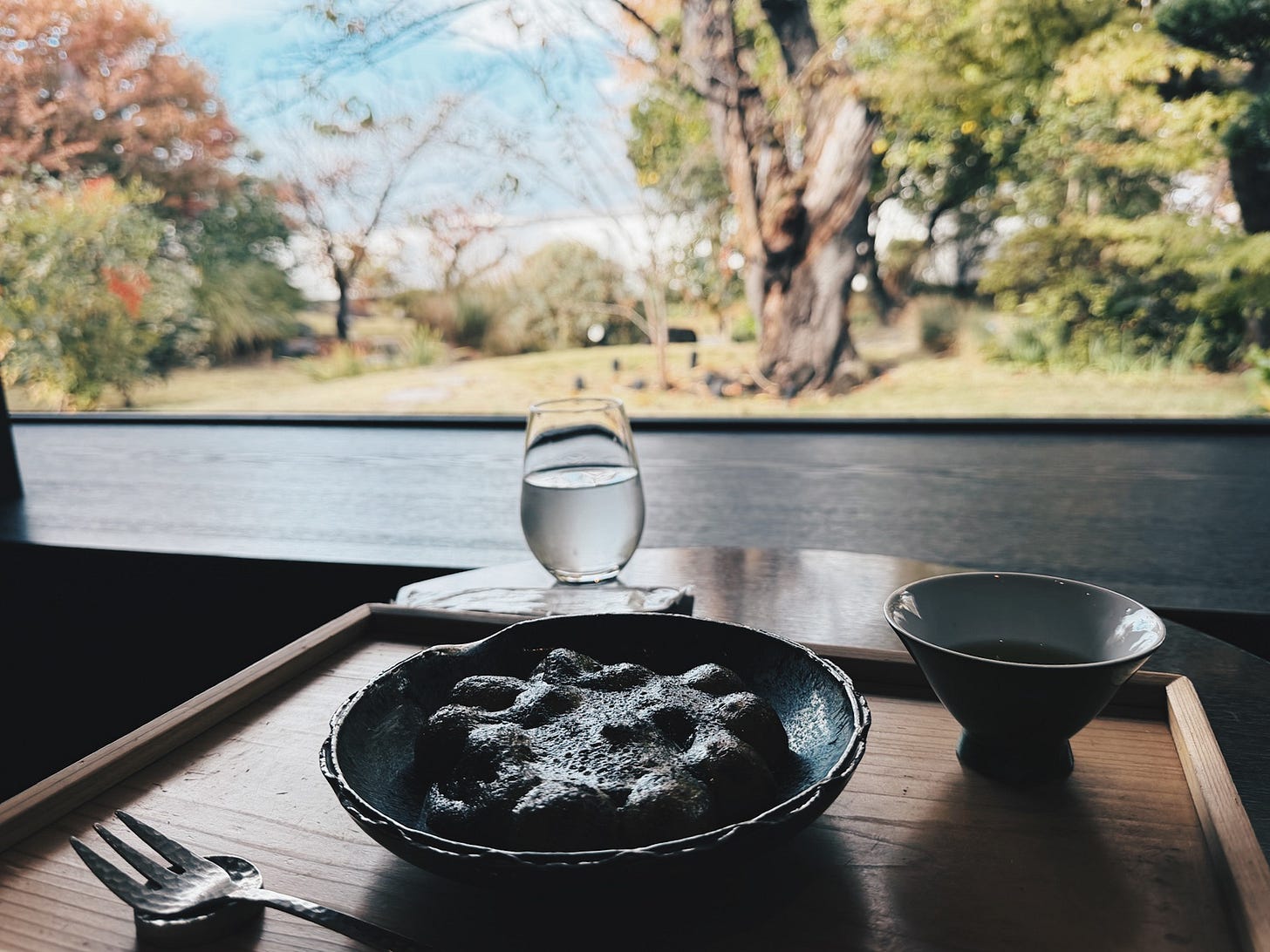 Seasonal Japanese confection served in a black lacquer bowl beside a window overlooking an autumn garden, Uji, Japan Seasonal Japanese confection served in a black lacquer bowl beside a window overlooking an autumn garden, Uji, Japan