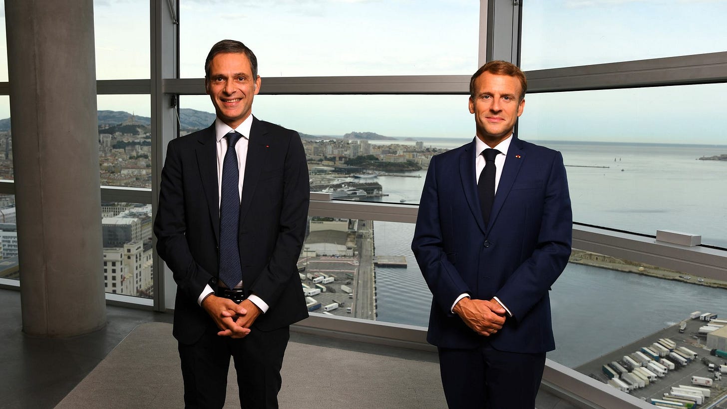 a person in a suit standing in front of a window a person in a suit standing in front of a window