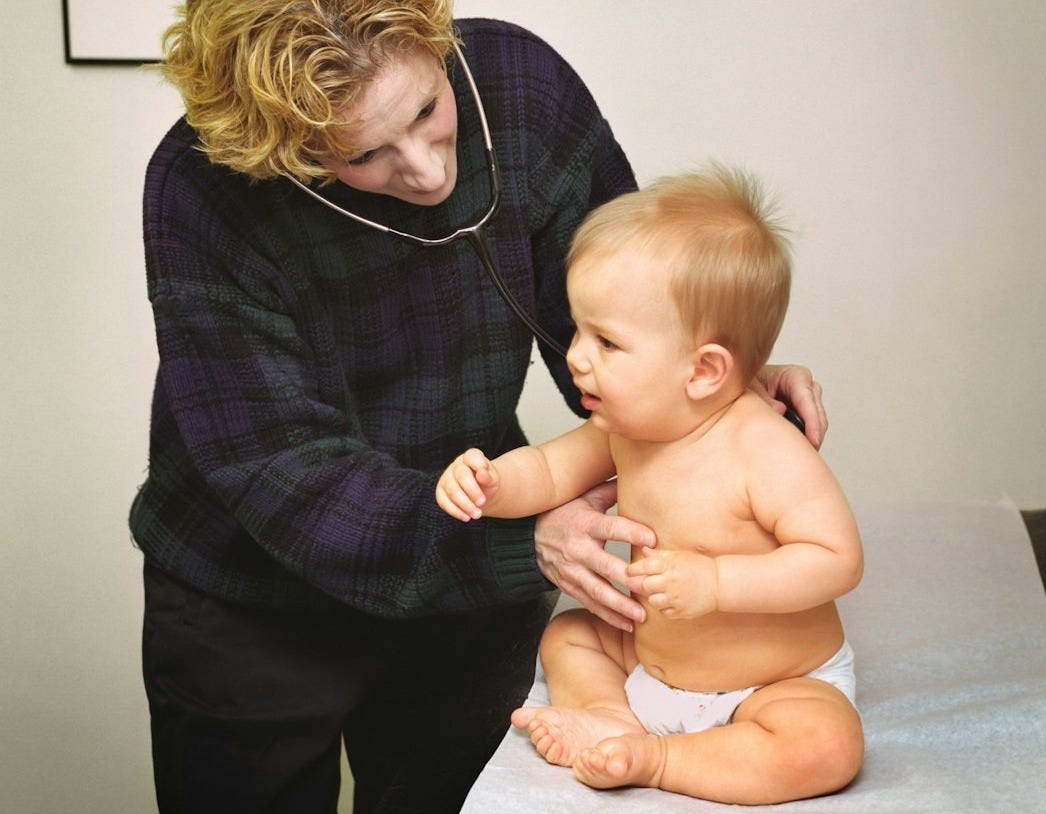 a woman holding a baby on top of a table