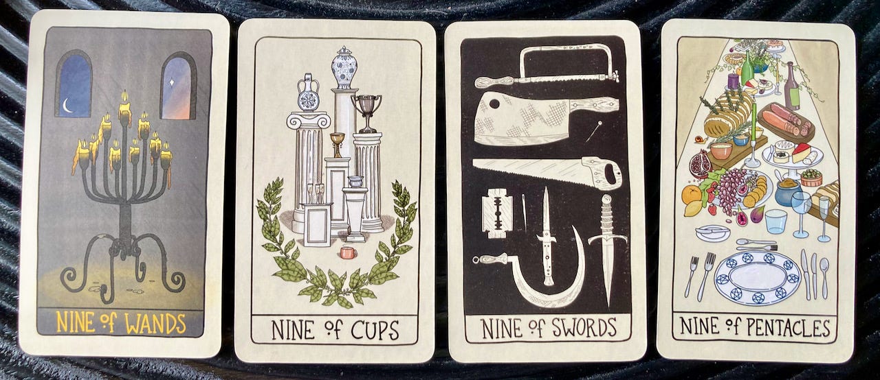 The four Minor Arcana nines from Fifth Spirit Tarot are lined up on a table. The 9 of Wands shows a candelabra with candles burnt down nearly to the nubs and dawn coming through a window. The 9 of Cups shows an assortment of fine vases, trophies, and champagne flutes sitting on grecian-style pillars, surrounded by a laurel wreath. The 9 of Swords shows an array of sharp tools including saws, knives, razors, and a sewing needle on a stark black background. The 9 of Pentacles shows a long table laden with a feast and set with one table setting.