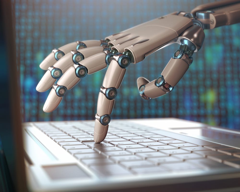 a robotic hand presses a key on a laptop keyboard