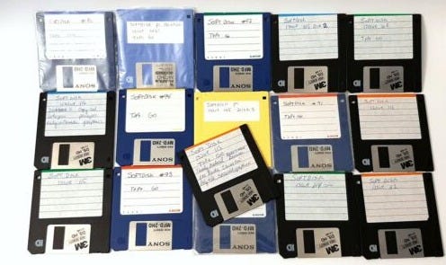 This may contain: a pile of floppy disk drives sitting next to each other on top of a table