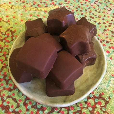 Fudge chocolate on a fork and molded chocolate squares and stars
