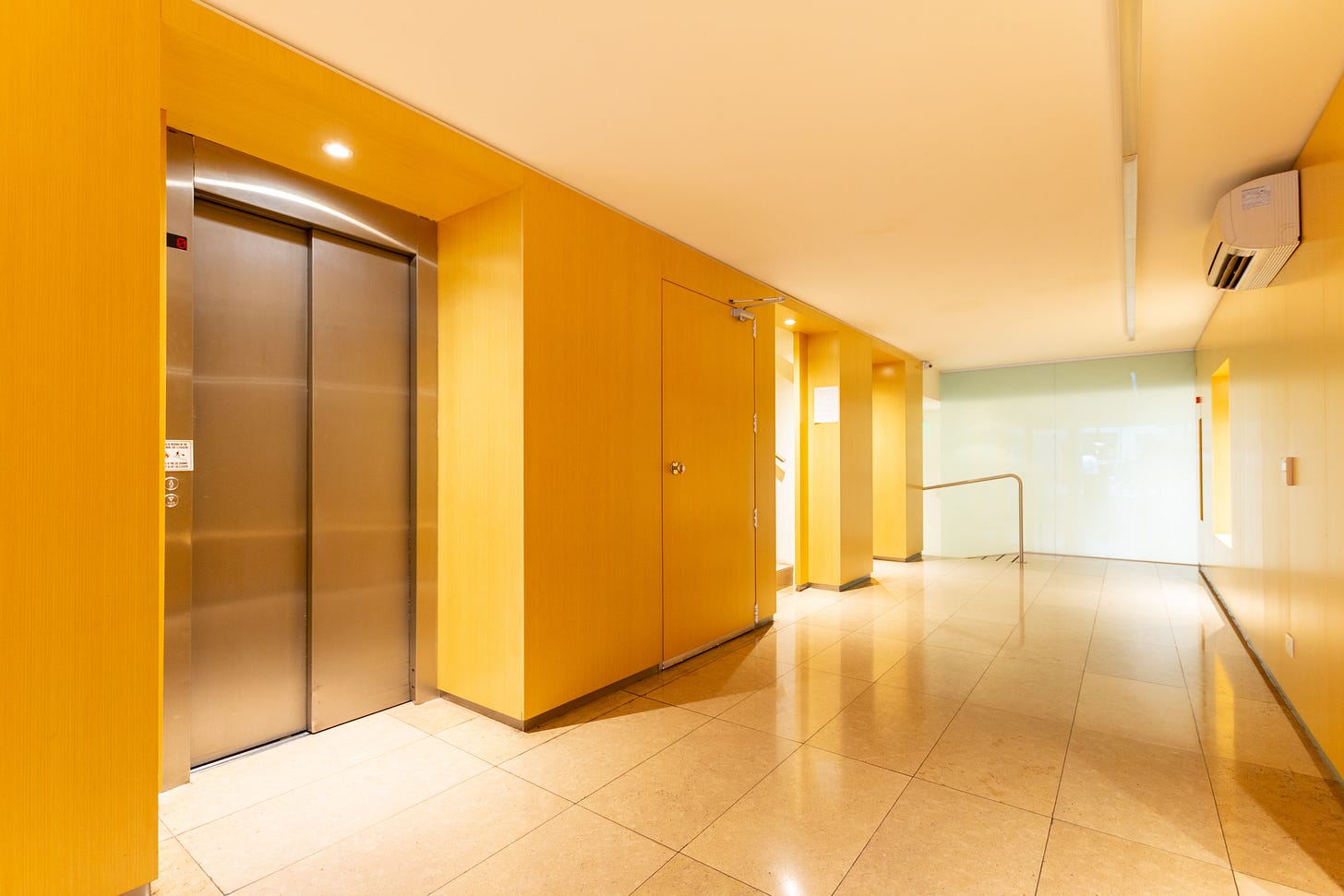 photo shoing doors of an elevator in a dark yellow corridor photo shoing doors of an elevator in a dark yellow corridor
