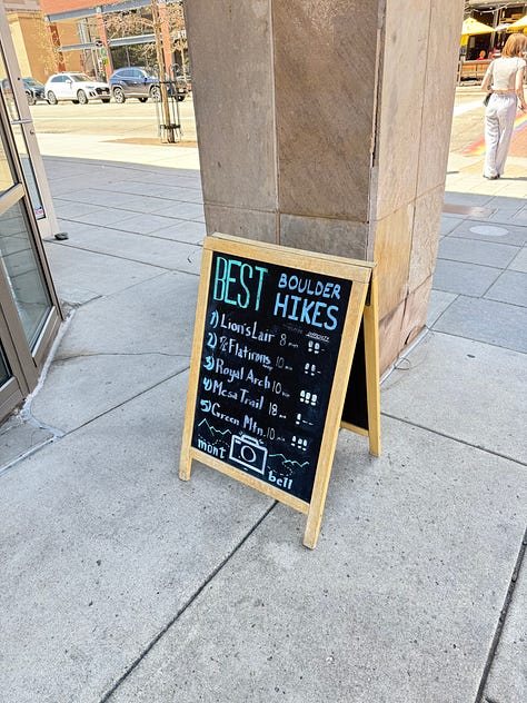 A photo gallery featuring moments from daily life and wellness: a charcuterie board, a cozy dog lounging on a bed, snowy mountain scenes, skiing, smiling couple, a local Boulder shop sign, spring flowers, a knit project, and a scenic desert hike.” This keeps it keyword-relevant (wellness, nature, lifestyle, Boulder, cozy, daily moments) and descriptive enough for accessibility.