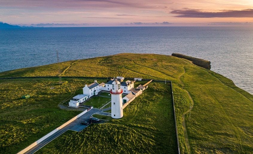 Historic lighthouse on Ireland's rugged coastline overlooking the Atlantic Ocean.