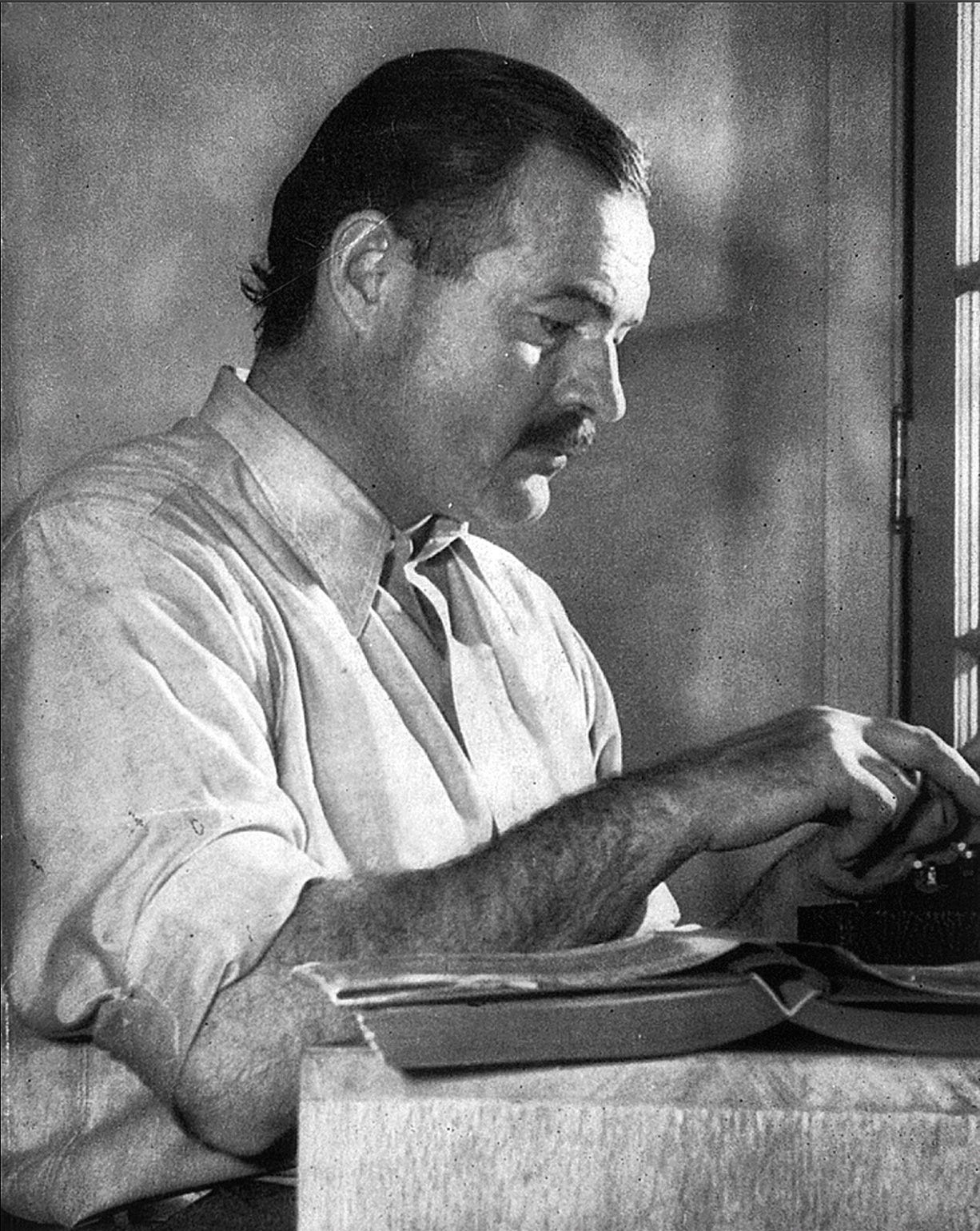 Black & white photo of Ernest Hemingway two-finger typing. Black & white photo of Ernest Hemingway two-finger typing.