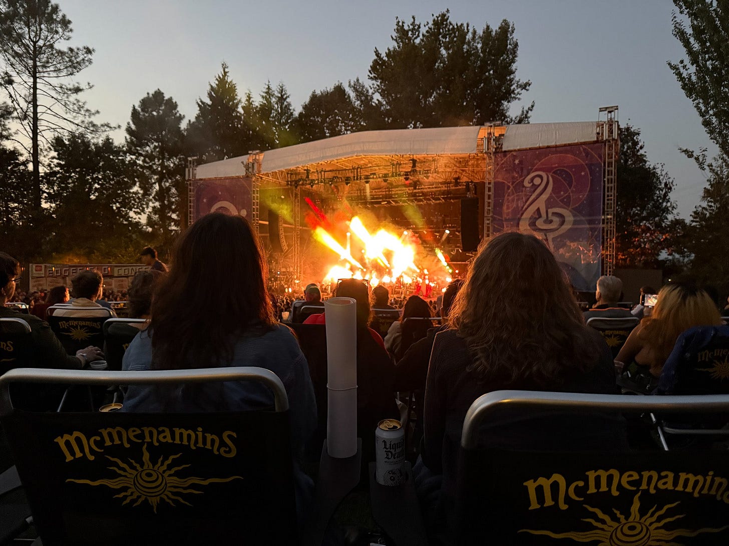 two people watching an outdoor concert