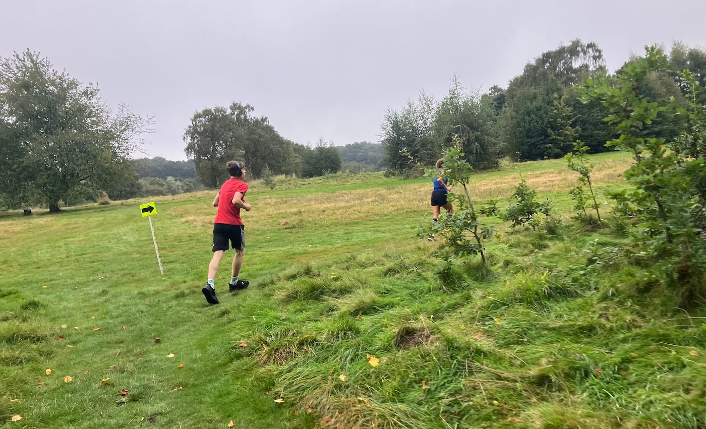 Runners head into a grassy field