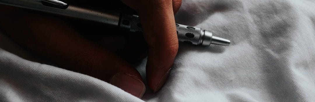 a person writing on a sheet with a pen a person writing on a sheet with a pen