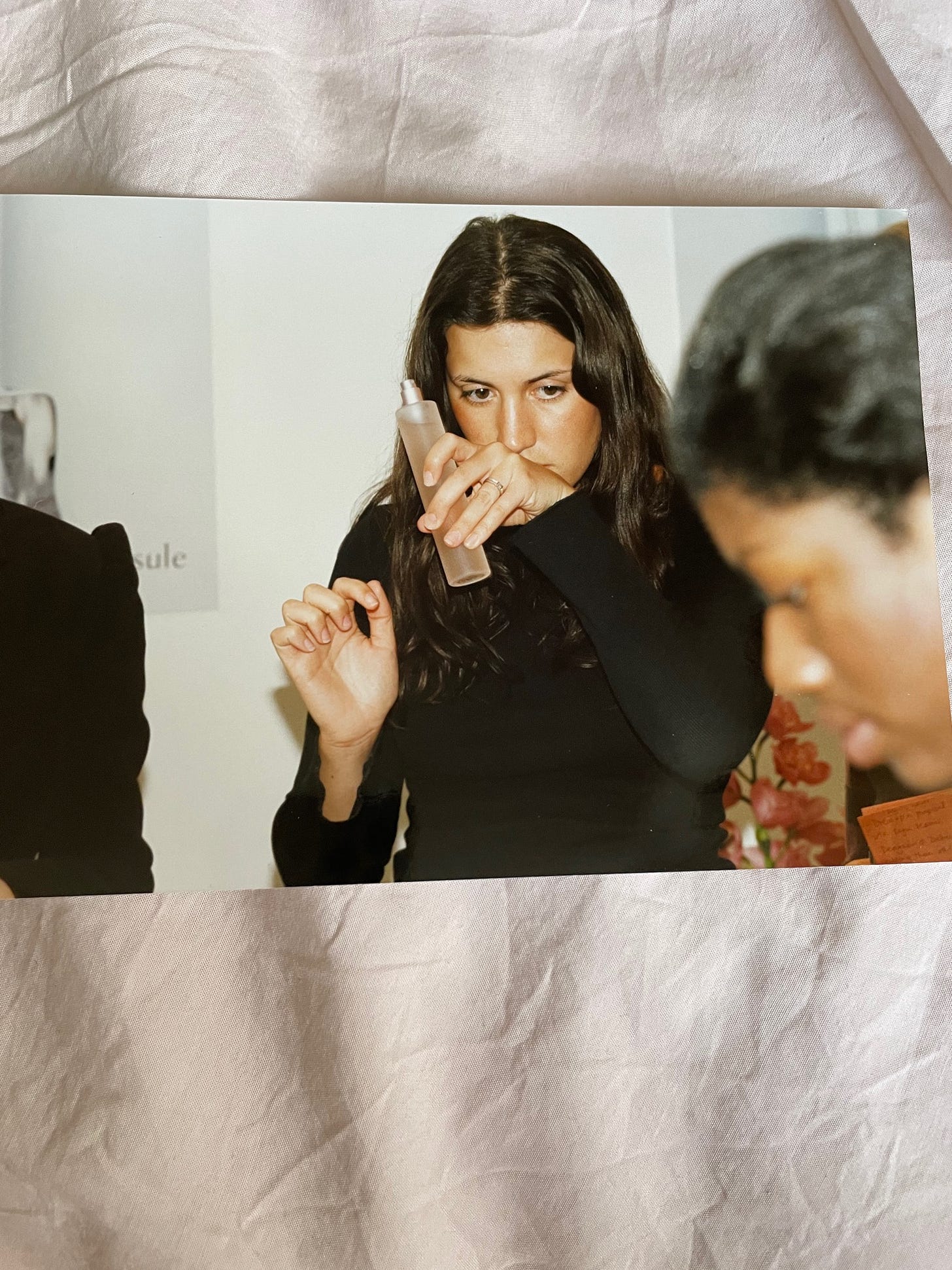 An old photograph of British Award-Winning Beauty Editor and founder of The Beauty Ed® Donna Francis at a 1990s product press launch, inspecting a beauty formula.