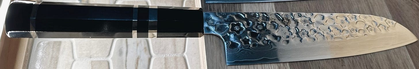 Patented hammered-sakura design reflecting light on a knife blade created by Kappabashi Knife Gallery. Patented hammered-sakura design reflecting light on a knife blade created by Kappabashi Knife Gallery.