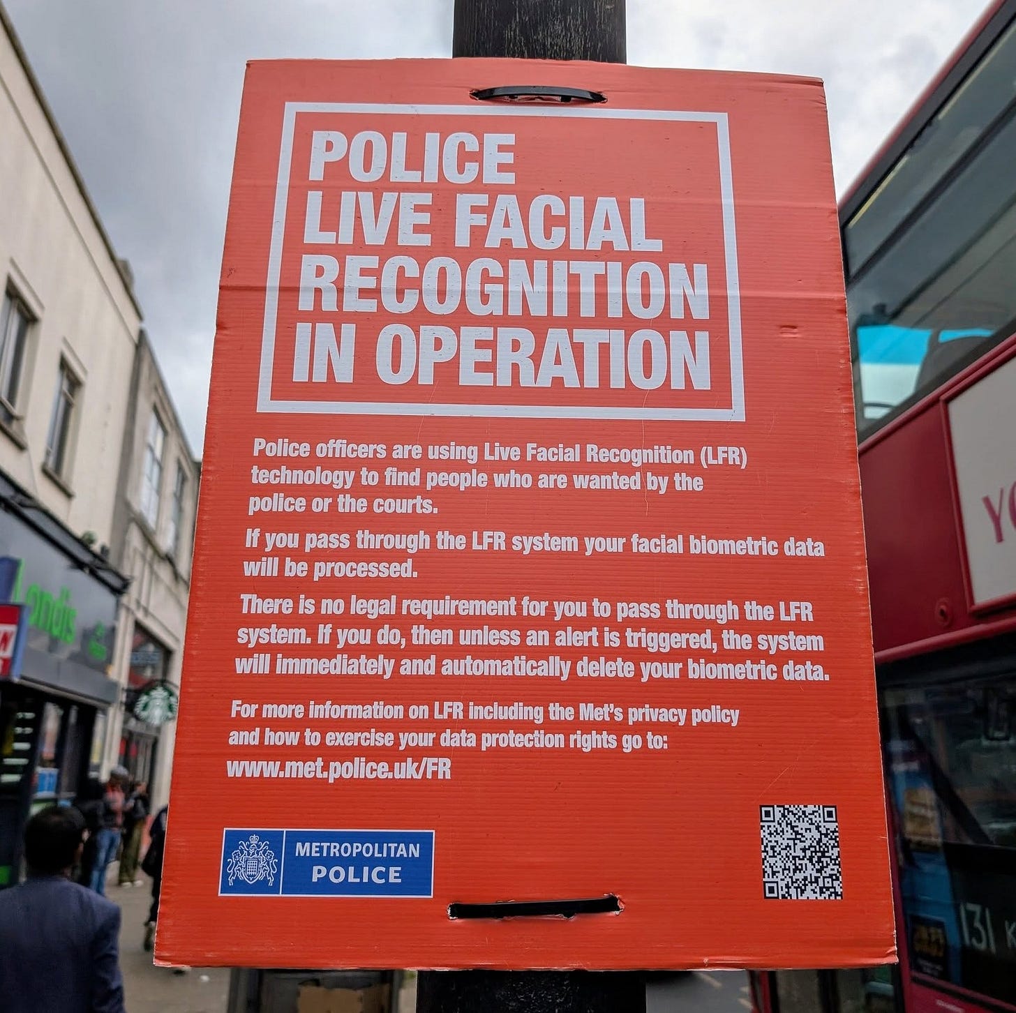 May be an image of 2 people and text that says "POLICE LIVE FACIAL RECOGNITION IN OPERATION Police officers are using Live Facial Recognition (LFR) technology find people who are wanted by the police the courts. If you pass through the LFR system your facial biometie data will be processed. There no legal requir requirement rement for you to pass passth through the LFR system. you then unless an alert triggerad, the system will immediately and automatically delete your biometric data. For more information LFR including the Met's privacy policy and how exercise your data protection rights ං to: www.met.police.uk/FR METROPOLITAN TAN POLICE"