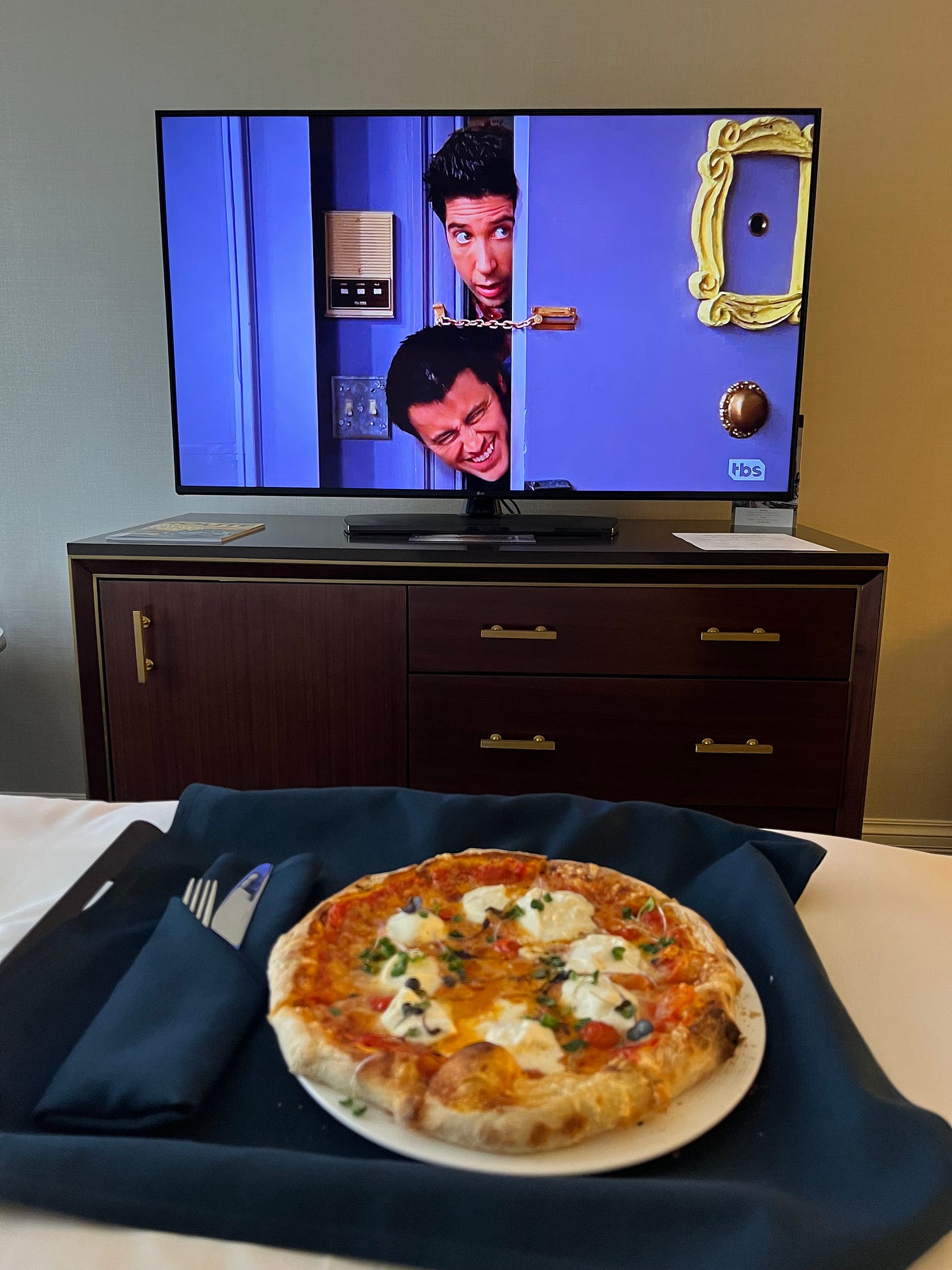 Episode of FRIENDS playing with a pizza on my hotel bed