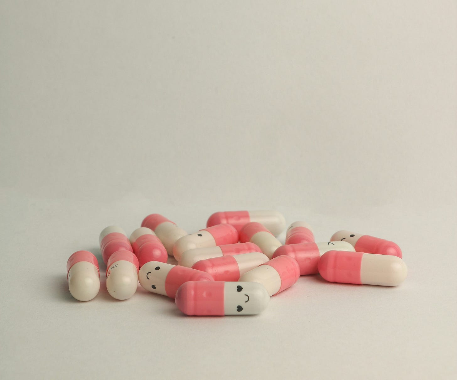 pills with smiley faces on them on a white background