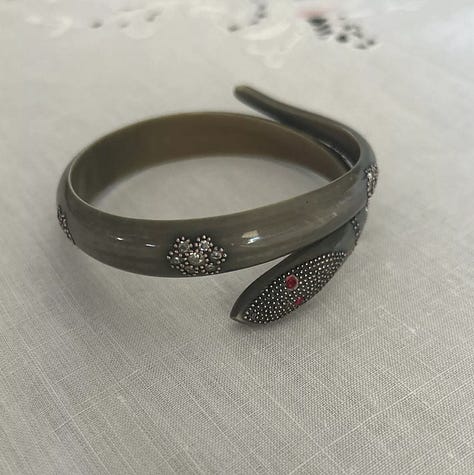 Stylized snake forms beginning in horn or shell are remade in early plastic approximations of natural materials.