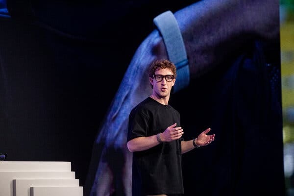 Mark Zuckerberg gestures with both hands while speaking from a stage. 