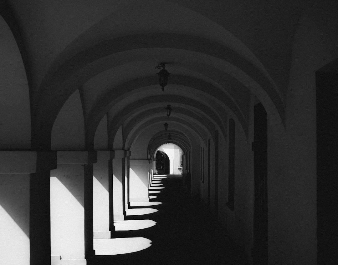 a black and white photo of a long hallway