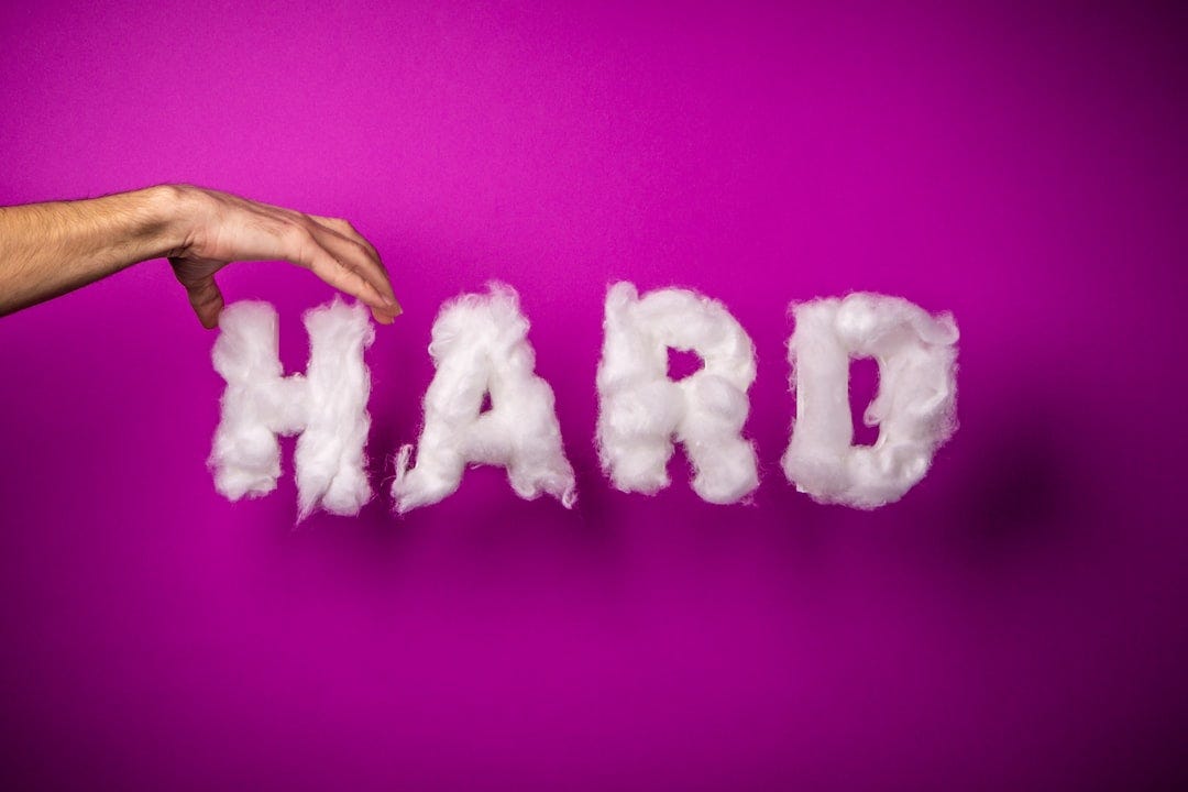 the word hard is written with clouds in front of a hand the word hard is written with clouds in front of a hand