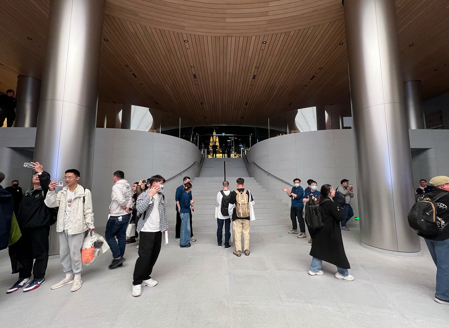 A view from the Forum level of Apple Jing'an, looking toward the plaza level. The upper store lights have been turned off.