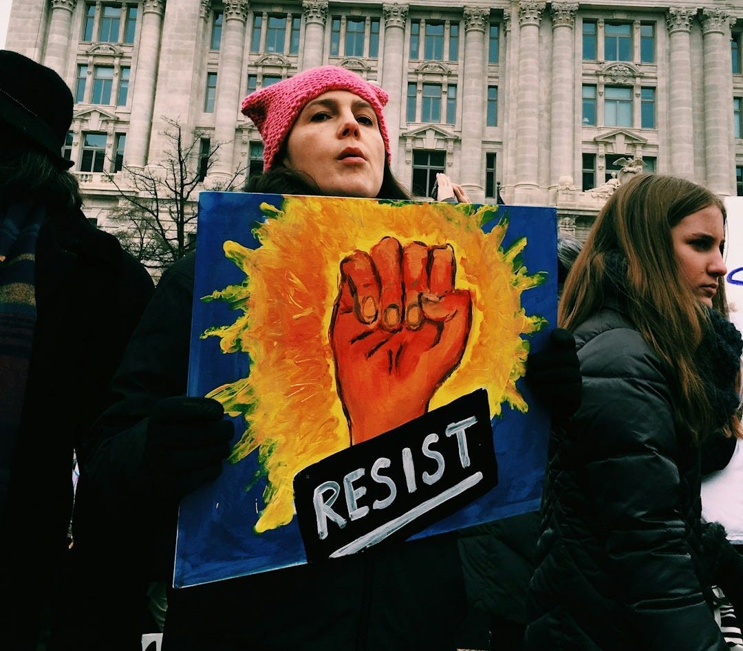 woman holding resist signage