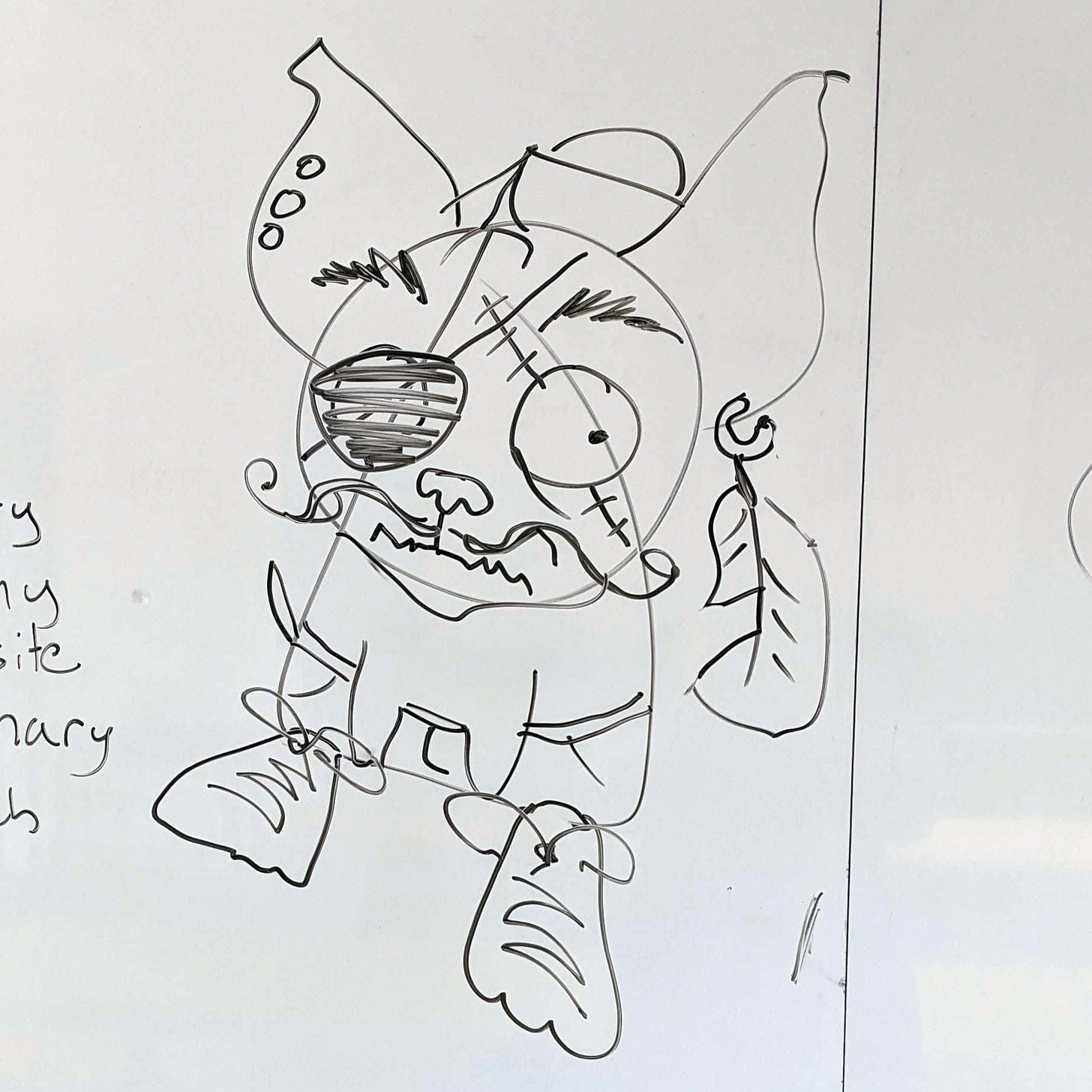 Drawing on a whiteboard in black of a shaped-based chihuahua modified to wear shorts, large shoes, earrings, a mustache, an eye patch, and a pirate hat.
