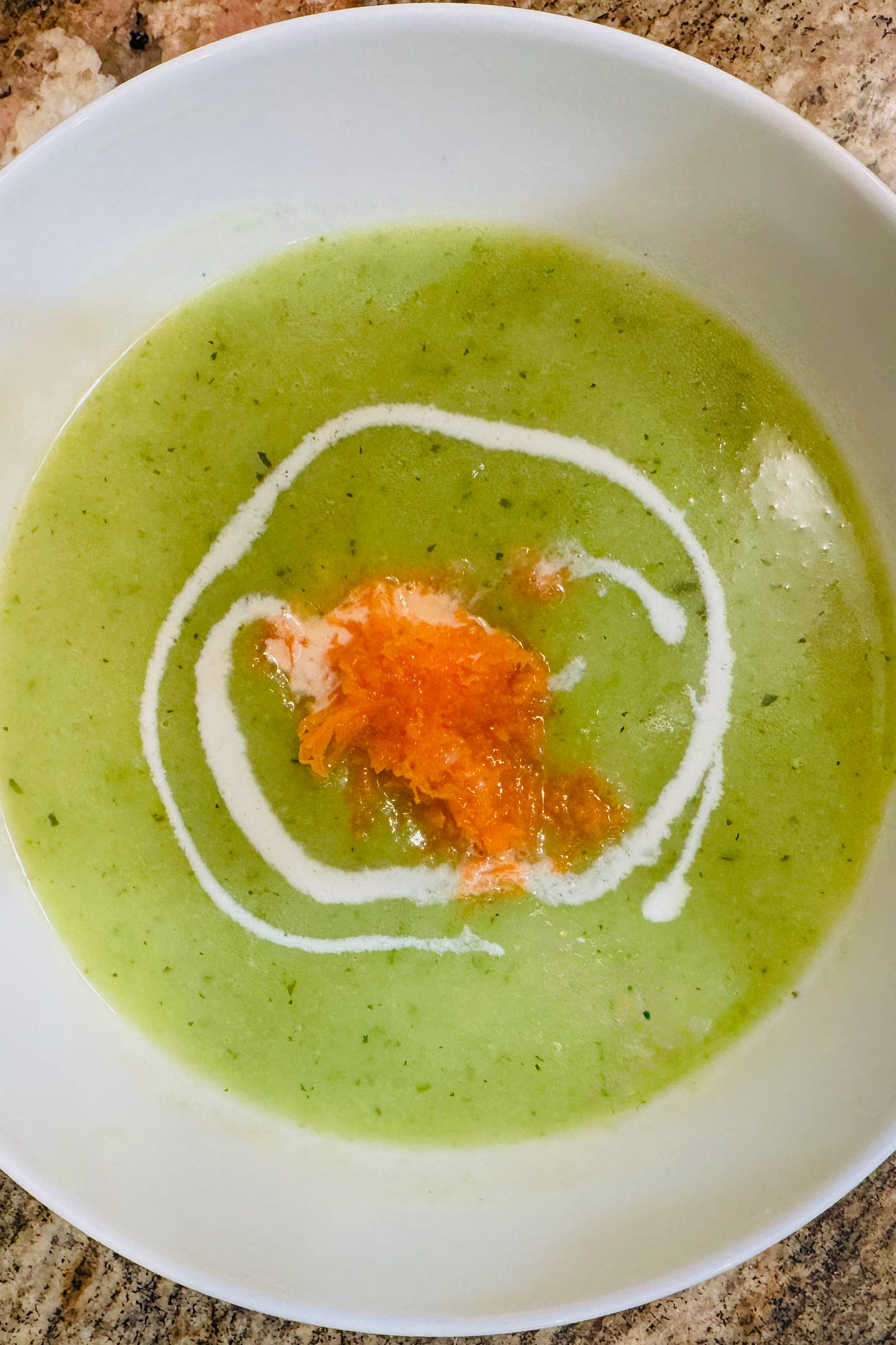 Patriot soup in a white bowl, vibrant green Irish vegetable soup topped with a swirl of cream and finely shredded carrot in the colors of the Irish flag Patriot soup in a white bowl, vibrant green Irish vegetable soup topped with a swirl of cream and finely shredded carrot in the colors of the Irish flag