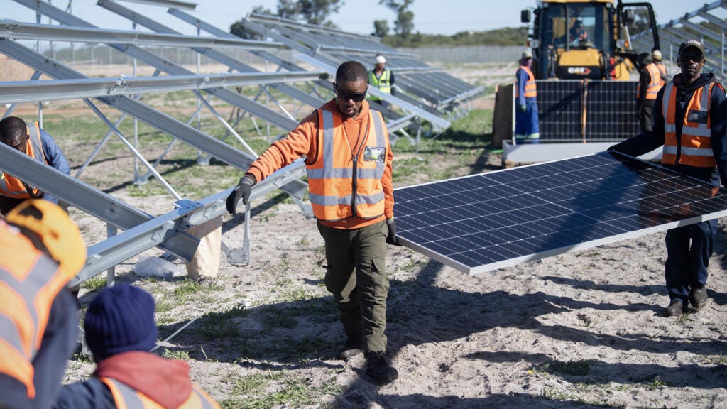 Workers carry solar panels at South Africa's first municipally owned solar plant in Atlantis, 40km from Cape Town, 5 June.