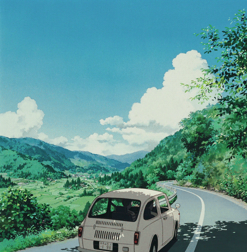 This may contain: a car is driving down the road with mountains in the background