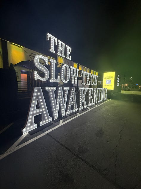 Three images, two of which show large signs in lights reading The Slow Tech Awakening and End Fast Tech. The third image is a real-life collage of old technology as an art display.