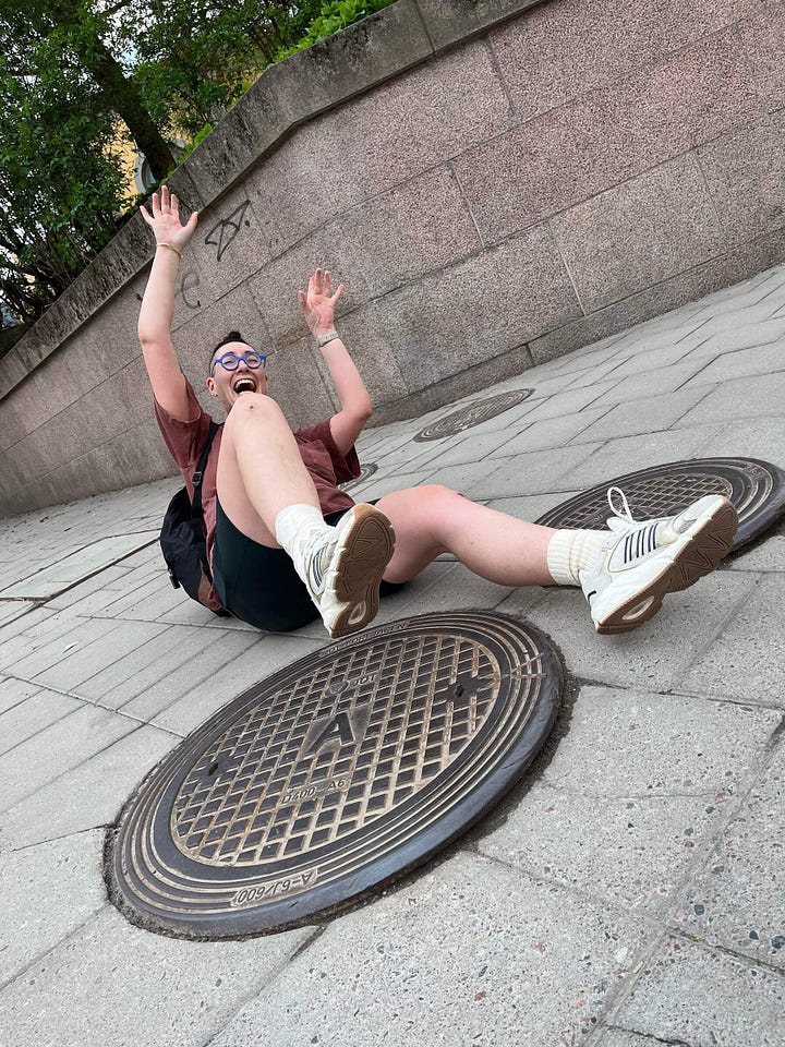 Two images of Shell dramatically posing on the ground as if they had just fallen and tripped over a manhole cover