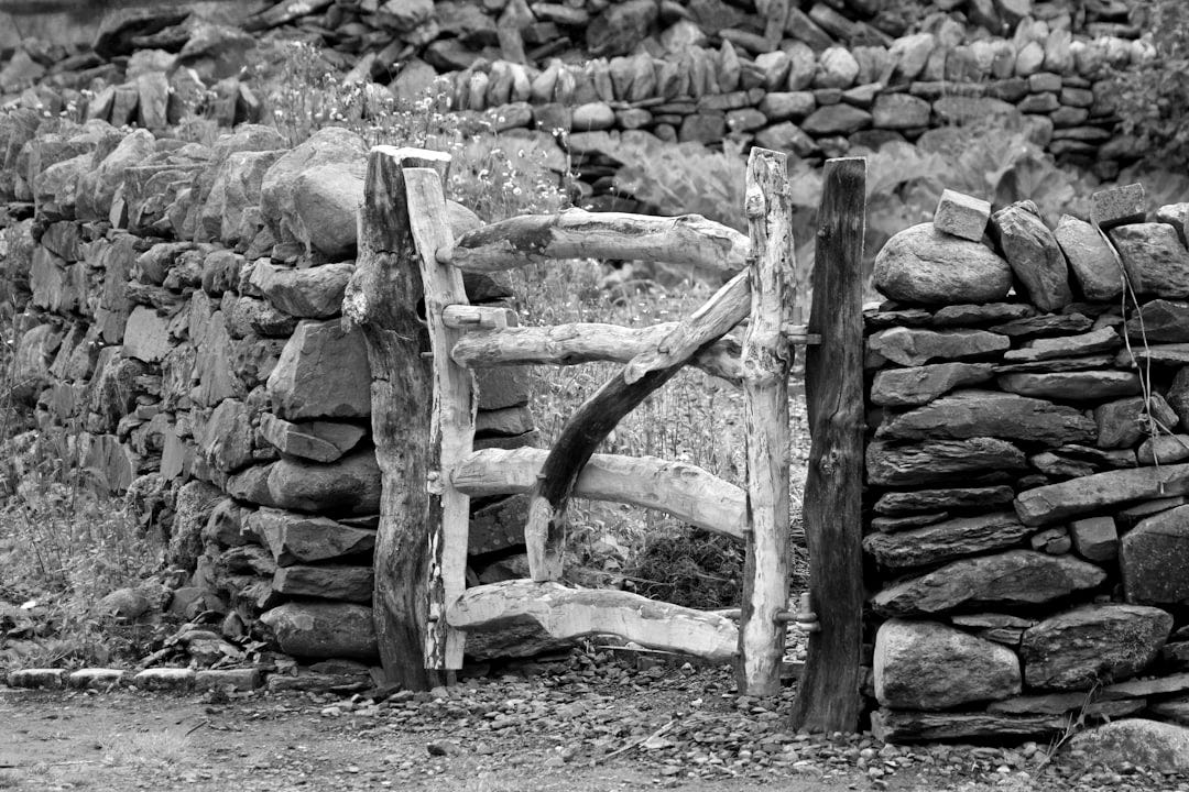 a wooden gate in front of a stone wall