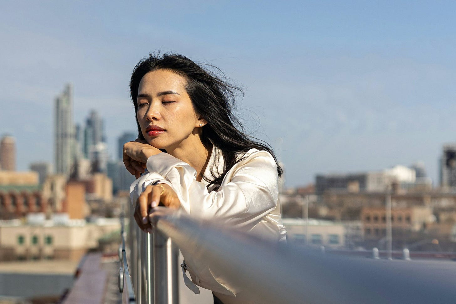 Brunette woman on a bridge with eyes closed to the wind Brunette woman on a bridge with eyes closed to the wind