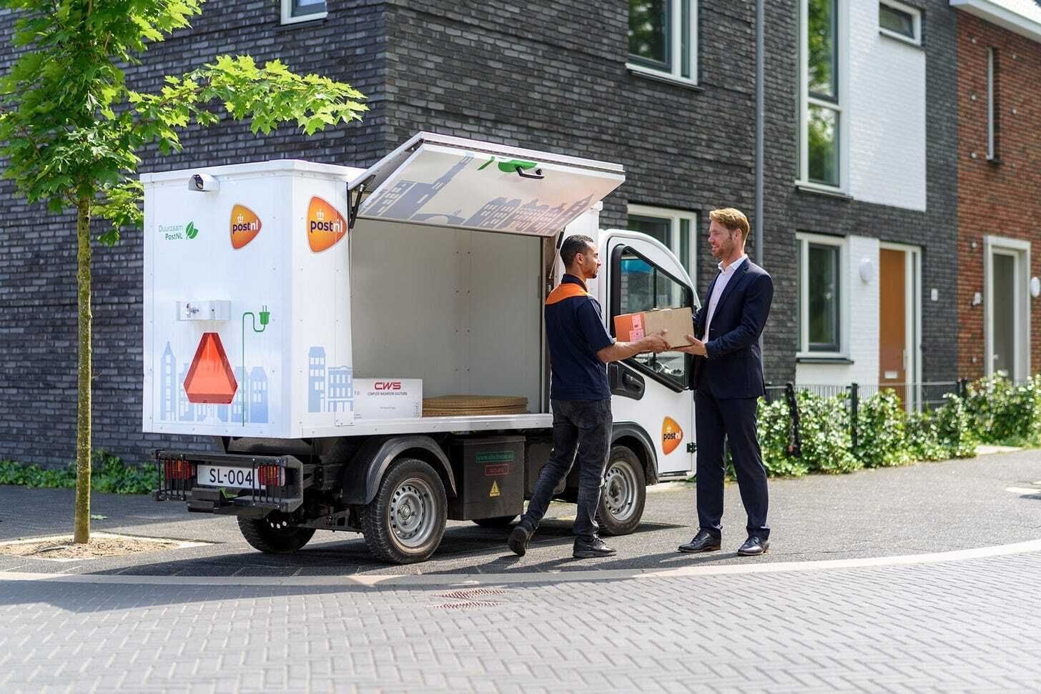 PostNL delivery man hands parcel to customer, Postnl Wants to Switch to Delivering Mail Every Other Day PostNL delivery man hands parcel to customer, Postnl Wants to Switch to Delivering Mail Every Other Day