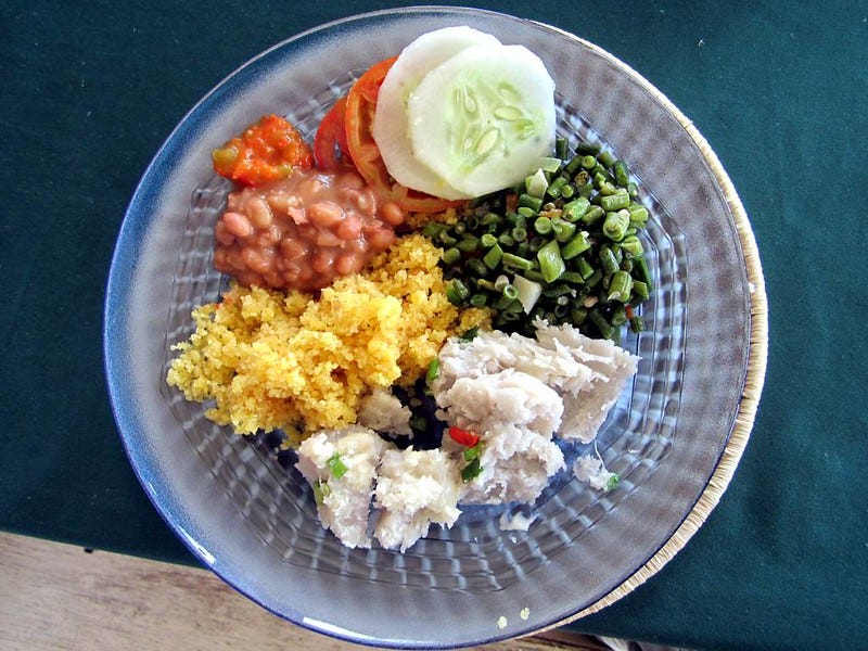A top-down view of a round plate that contains a colorful assortment of food. A top-down view of a round plate that contains a colorful assortment of food.