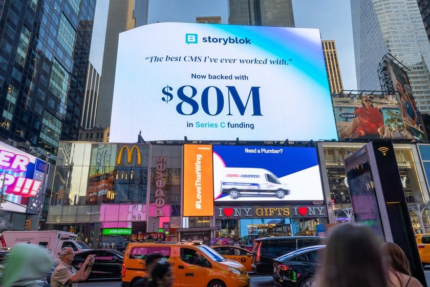 A large white and blue billboard towers over a busy street, announcing that Storyblok has raised $80 million in Series C funding.