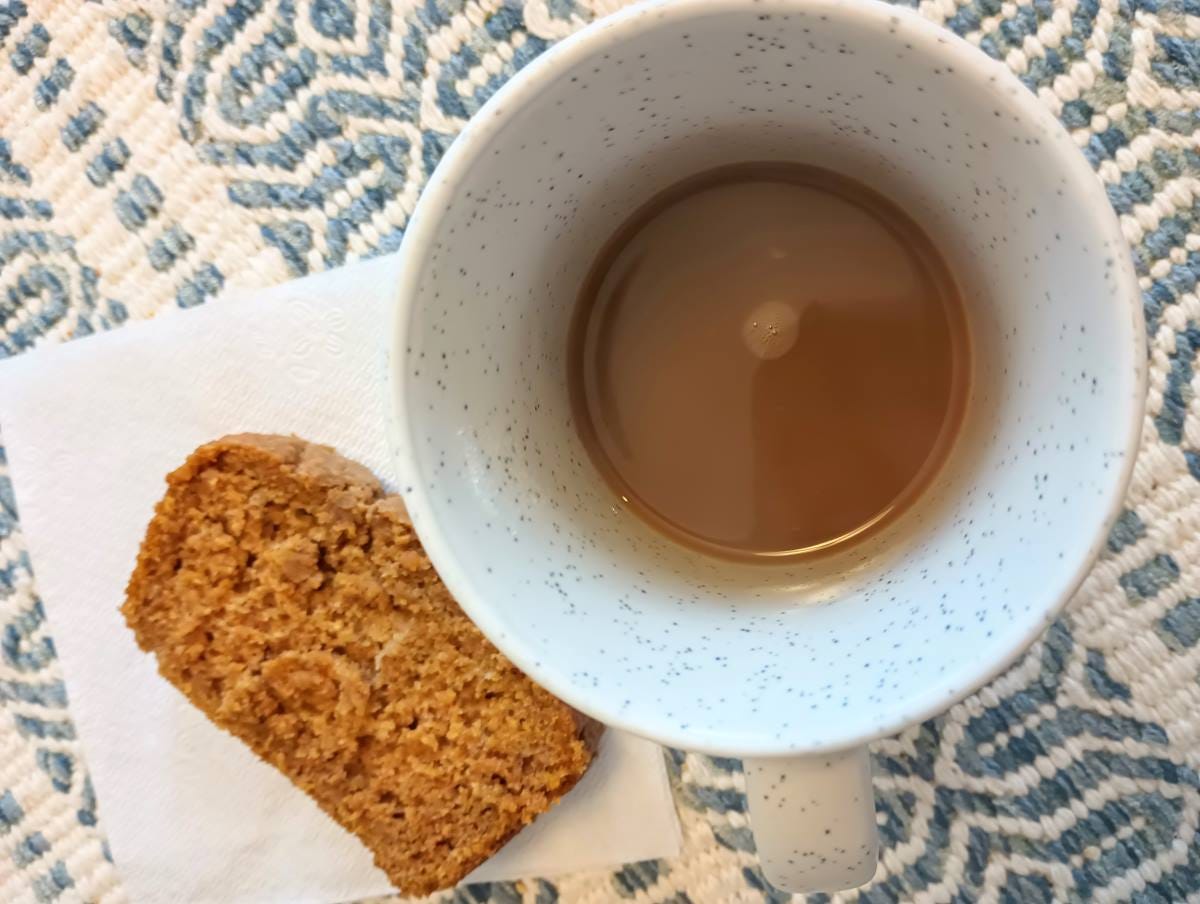 Cinnamon Maple Pecan Coffee next to slice of pumpkin bread